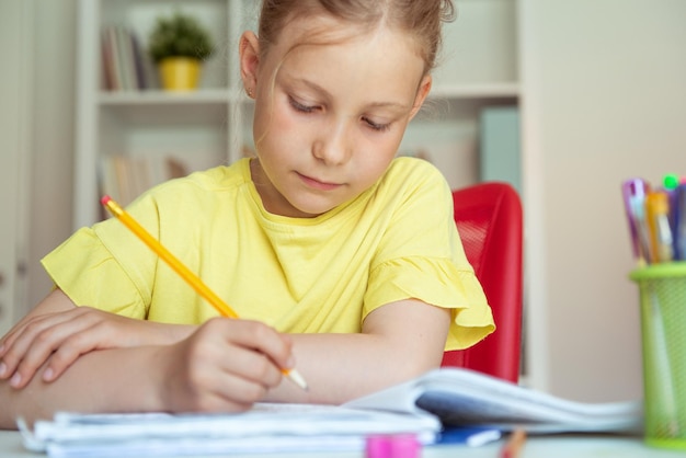 Une jolie fille allongée sur la table à la maison.