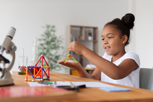 Photo jolie fille en apprenant plus sur la chimie en classe