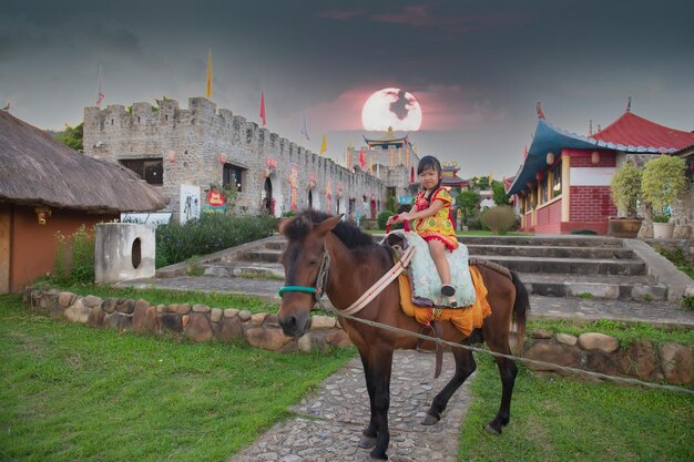 Jolie fille asiatique monter à cheval