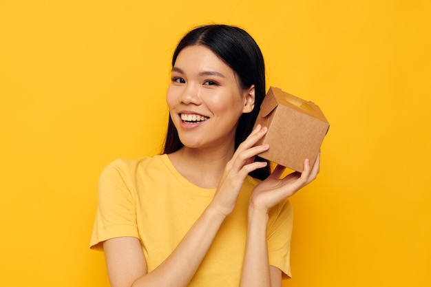 Jolie fille asiatique avec une petite boîte dans ses mains tir monochrome