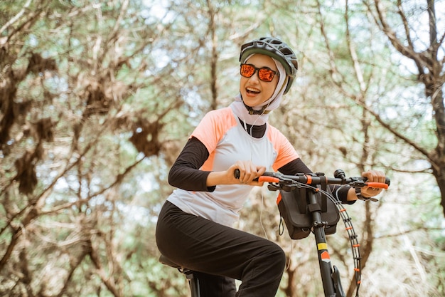 Jolie Fille Asiatique Voilée à Lunettes De Soleil Portant Des écouteurs à Vélo