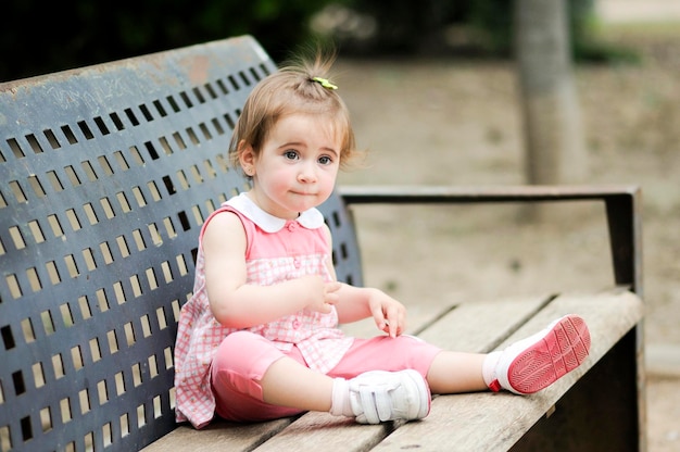 Une jolie fille assise sur un banc.