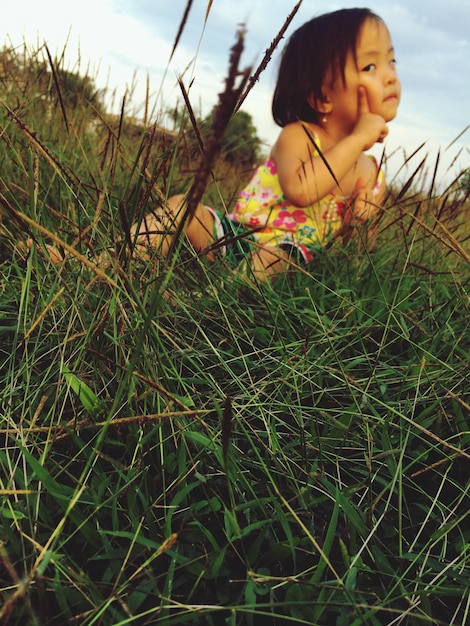 Une jolie fille assise sur un champ d'herbe