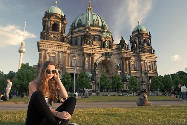 Jolie fille assise devant la cathédrale de Berlin portant des lunettes de soleil