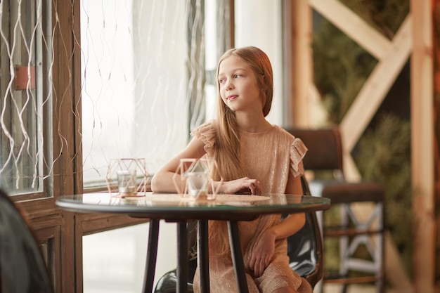 Jolie fille assise à une table dans un café