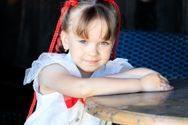 Jolie fille assise à une table à kafe en été. photo de haute qualité