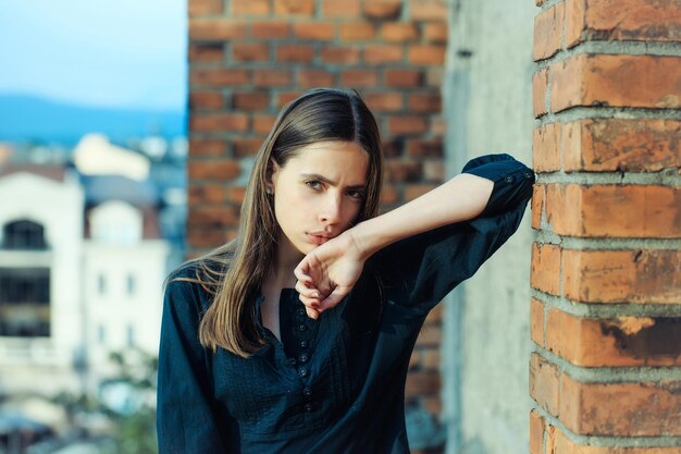 Photo jolie fille au mur de briques