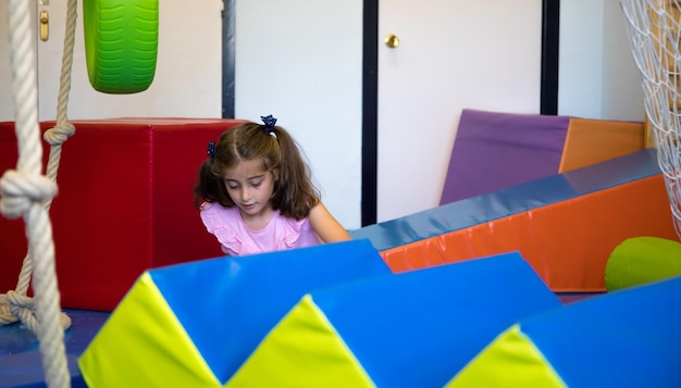 Jolie fille aux yeux clairs allongée sur des nattes dans le gymnase de son école.