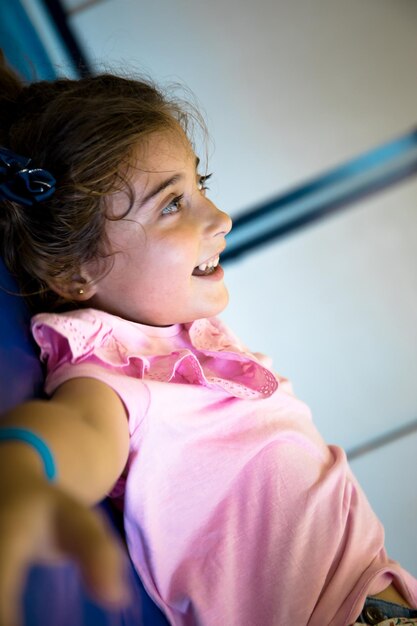 Jolie fille aux yeux clairs allongée sur des nattes dans le gymnase de son école.