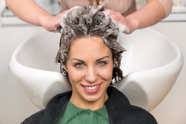 Jolie fille ayant les cheveux lavés au salon