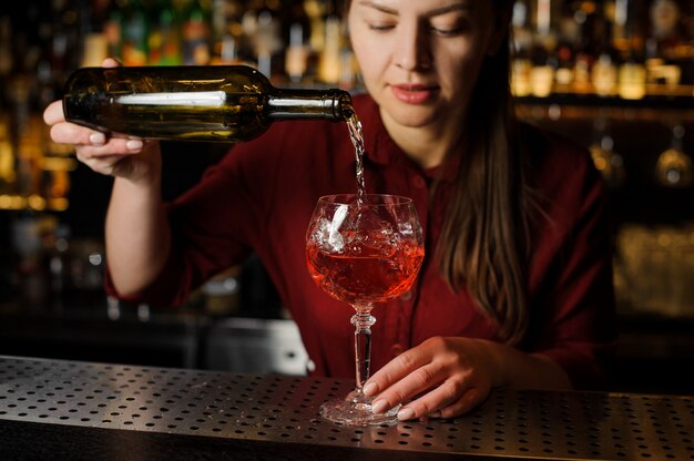 Jolie fille barman prépare un cocktail alcoolisé Spritz Veneziano