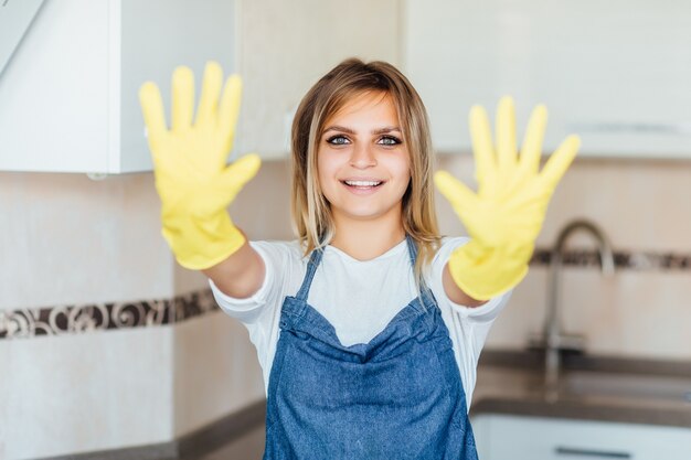 Jolie fille blonde et jolie de l'entreprise de nettoyage en uniforme prête pour le nettoyage de la chambre.