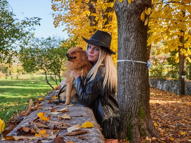 Jolie fille blonde joue avec un chien de Poméranie