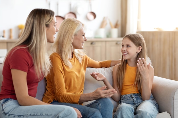 Photo jolie fille blonde préadolescente partageant des secrets avec maman et grand-mère