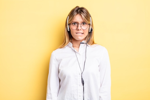 Jolie fille blonde à la recherche de concept de casque perplexe et confus