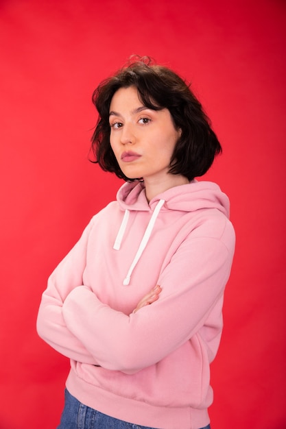 Photo jolie fille brune en sweat à capuche rose posant pour l'égalité des sexes liberté des femmes