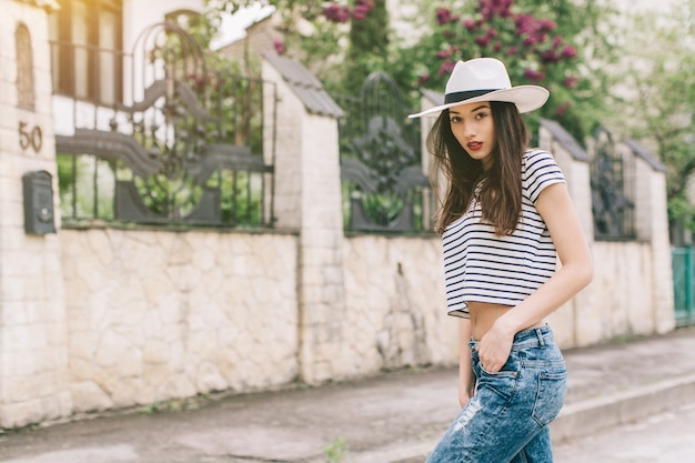 jolie fille avec un chapeau marchant