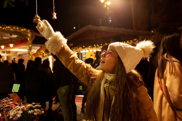 Jolie fille choisit un jouet de Noël au marché de Noël magique Vacances d'hiver