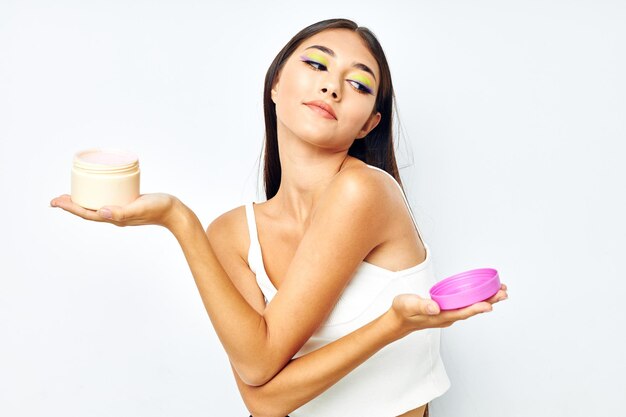 Jolie fille dans un bocal en jersey blanc avec un modèle de studio de cosmétiques inchangé