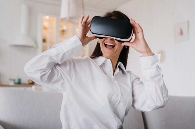 Photo jolie fille dans un casque de réalité virtuelle réalité augmentée une femme heureuse tient des lunettes 3d vr à l'intérieur