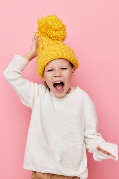 Jolie fille dans un pull et un chapeau enfance inchangée