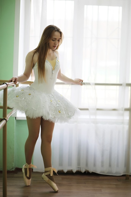 Jolie fille danseuse de ballet pratiquant à l'intérieur