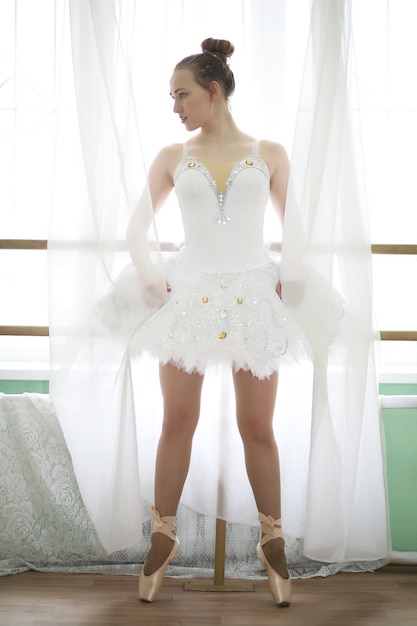 Jolie fille danseuse de ballet pratiquant à l'intérieur