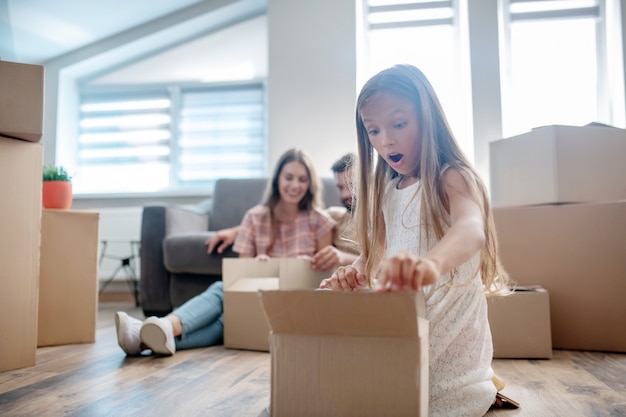 Jolie fille déballant une boîte en carton