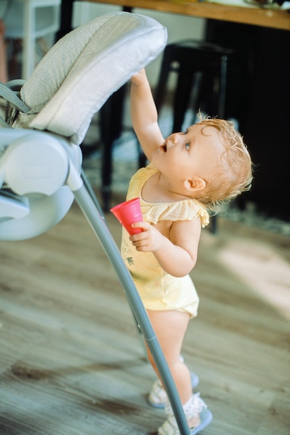 Photo une jolie fille debout près de la chaise à la maison