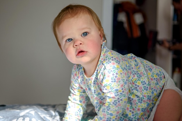 Photo jolie fille de dix mois jouant seule dans un berceau à la maison l'après-midi ou le matin