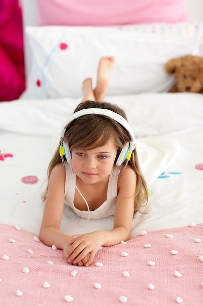 Jolie fille écoutant de la musique au lit