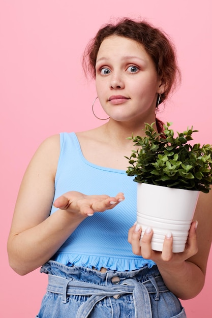 Jolie fille fleur en pot posant des arrière-plans isolés végétaux inchangés