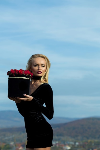 Jolie fille avec des fleurs en boîte