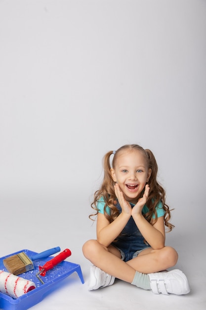 Jolie fille sur fond blanc avec des outils de construction