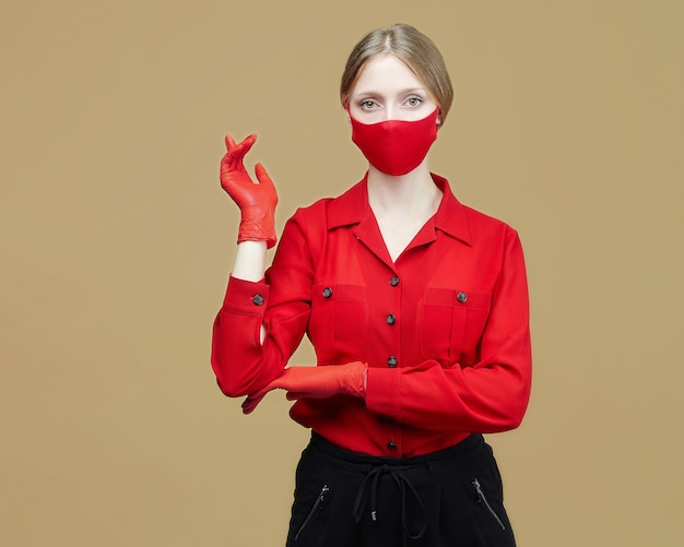 Jolie Fille En Gants Rouges Et Masque. Le Concept De Prévention Du Coronavirus Covid 19. Séance Photo En Studio Sur Fond Jaune