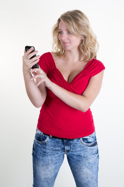 Jolie fille avec un haut rouge en regardant son téléphone portable