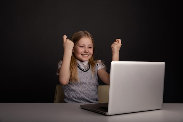 Jolie fille heureuse regardant l'ordinateur et se sentant si heureuse isolée