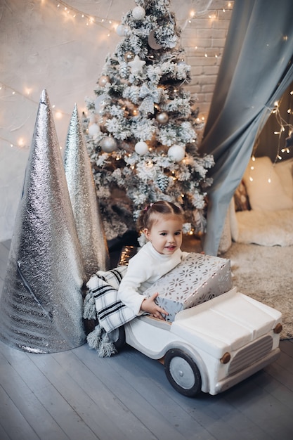 Jolie fille heureuse tenant le cadeau de Noël. Période de Noël.