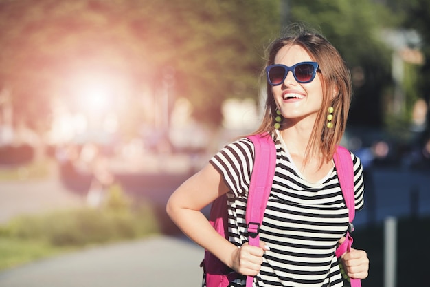 Jolie fille hipster à lunettes de soleil souriant