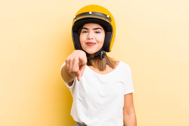 Jolie fille hispanique pointant vers la caméra en vous choisissant le concept de moto