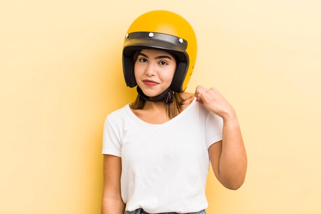 Jolie fille hispanique à la recherche d'un concept de moto arrogant, positif et fier