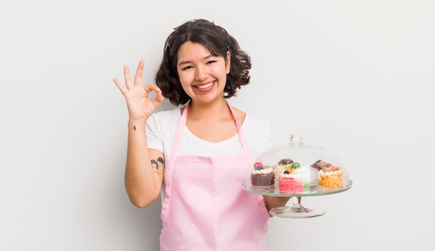 Jolie fille hispanique se sentant heureuse de montrer son approbation avec un geste correct concept de gâteaux faits maison