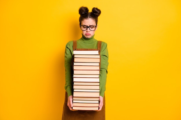 Jolie fille intellectuelle portant la science du livre isolé brillant vif éclat couleur jaune vif