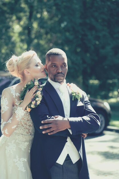 Jolie fille ou jolie mariée étreignant le beau marié afro-américain