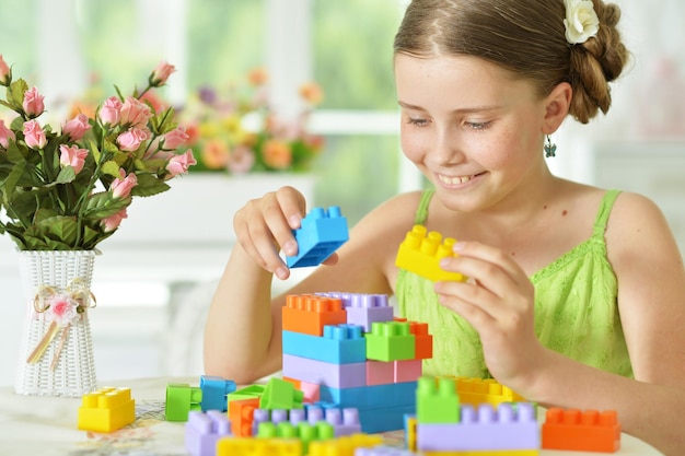 Jolie fille jouant avec des blocs en plastique