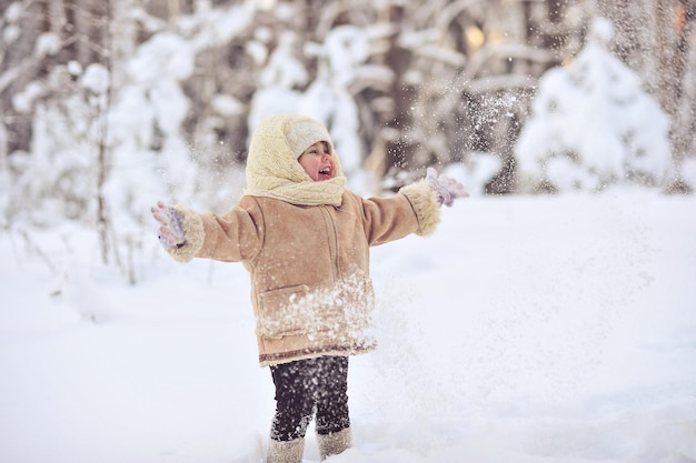 Une jolie fille jouant sur le champ de neige