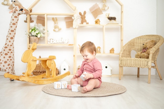 Jolie fille jouant avec des jouets naturels en bois dans la chambre des enfants à la maison jouets éducatifs pour enfants intérieur de la chambre des enfants