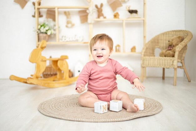 Jolie fille jouant avec des jouets naturels en bois dans la chambre des enfants à la maison jouets éducatifs pour enfants intérieur de la chambre des enfants