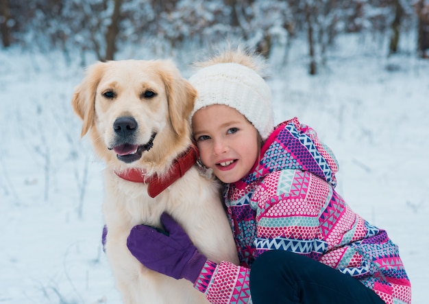 Jolie fille jouant avec son chien un jour d'hiver