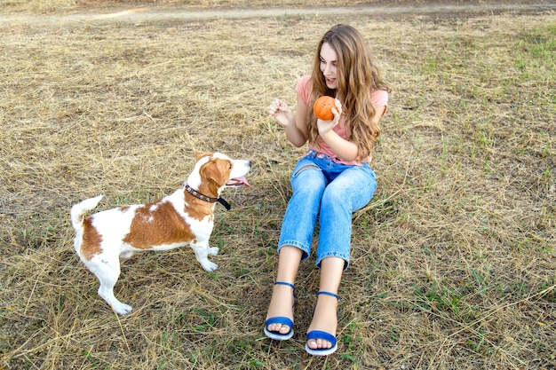 Jolie fille joue avec son chien dans le parc